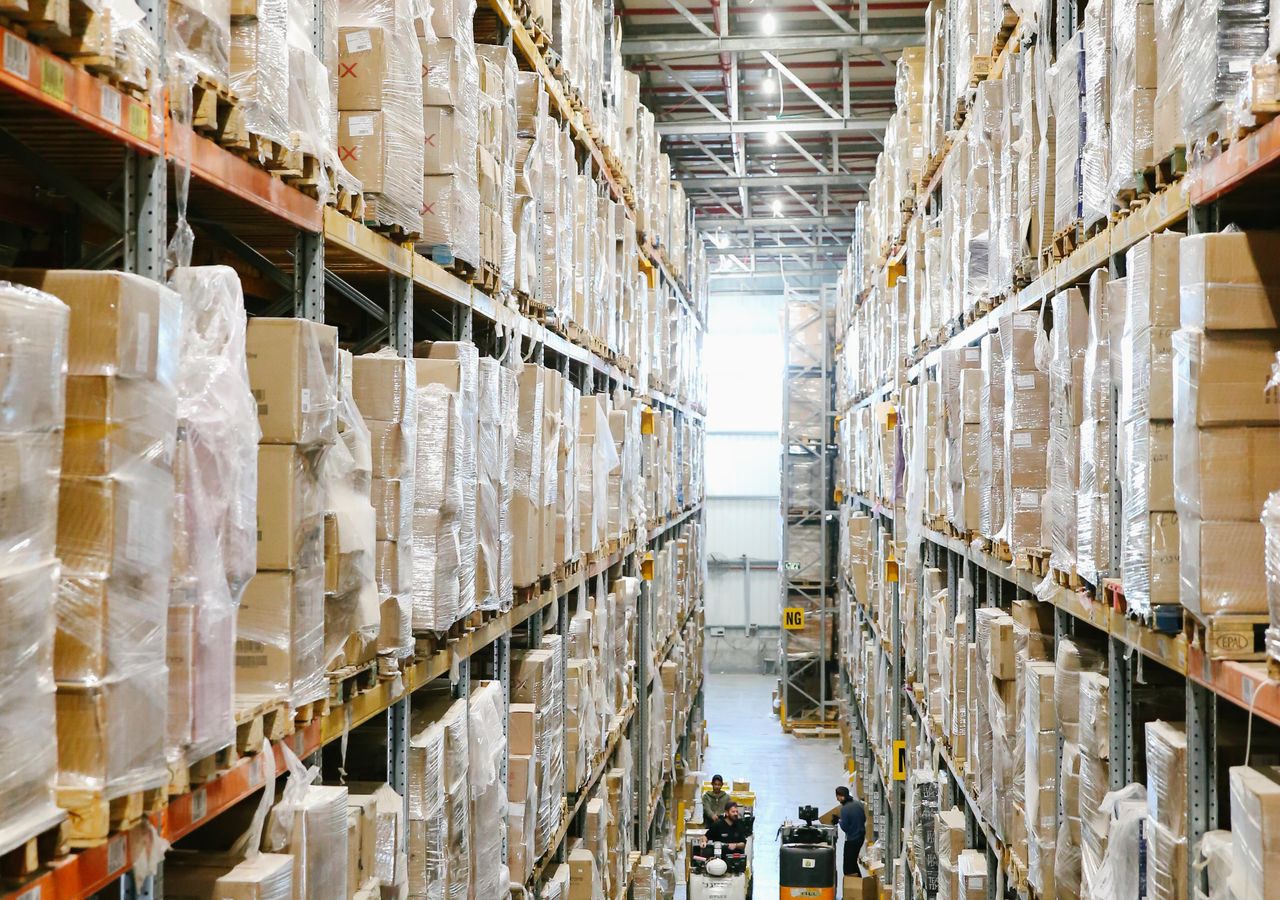 Blick in eine Lagerhalle mit vollen Hochregalen — Fulfillment-Center im Betrieb